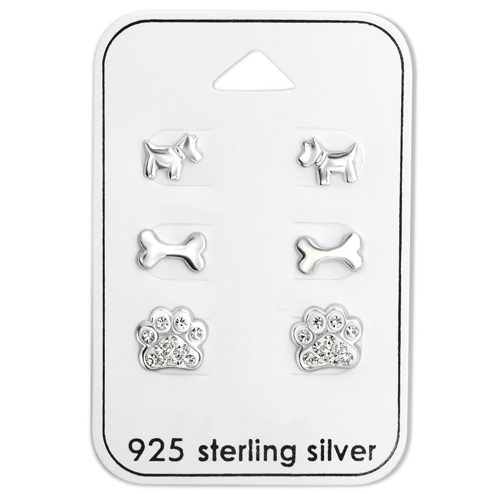 This set includes three different themed sterling silver dog themed kids earrings. The first earring is a dog body stud, then a dog bone silver stud, then one of our popular sparkling diamonte rhinestone paw print earrings.
